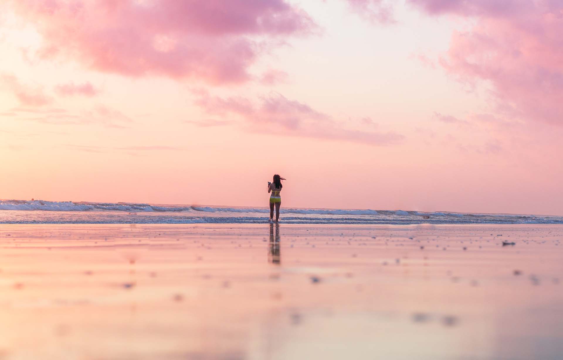 Woman on the beach with pink atmosphere - Header Image for the You are Enough Blog Post