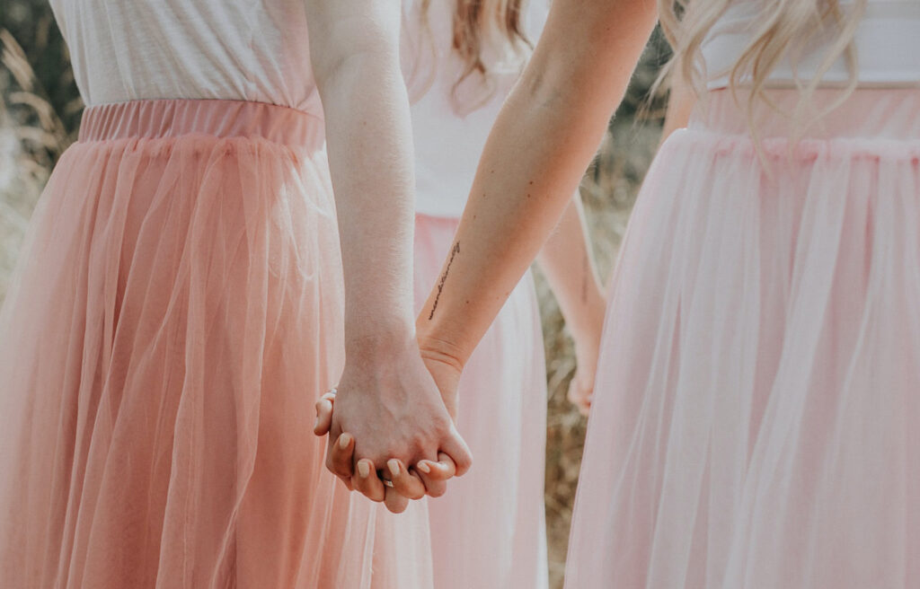 Girls holding hands and wearing pink tulle skirts