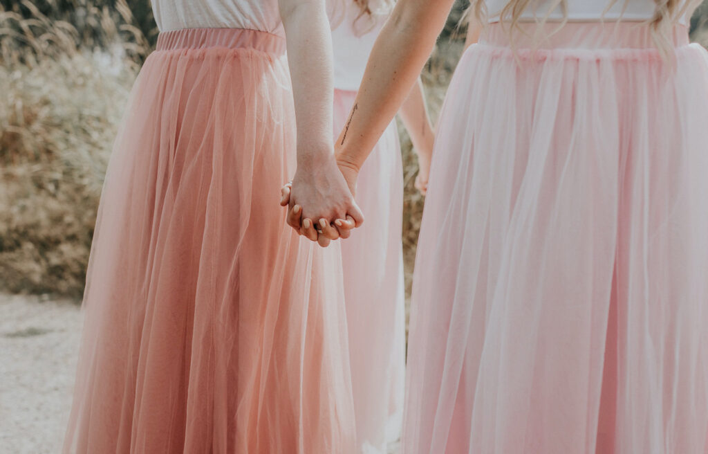 Girls holding hands and wearing pink tulle skirts